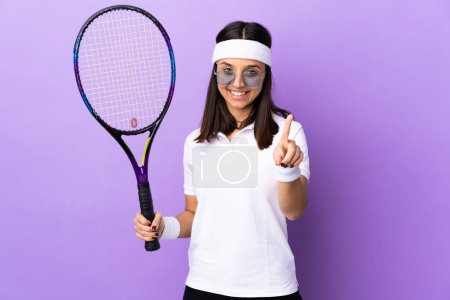 Téléchargez les photos : Jeune joueuse de tennis sur fond isolé montrant et levant un doigt - en image libre de droit