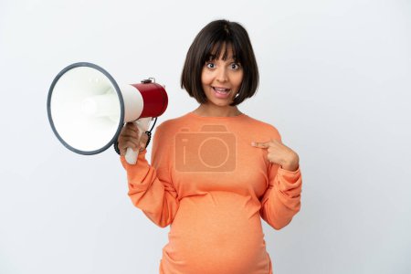 Foto de Joven mujer embarazada de raza mixta aislada sobre fondo blanco sosteniendo un megáfono y con expresión facial sorpresa - Imagen libre de derechos