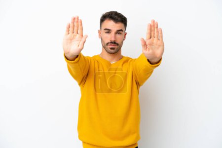 Photo for Young caucasian man isolated on white background making stop gesture and disappointed - Royalty Free Image