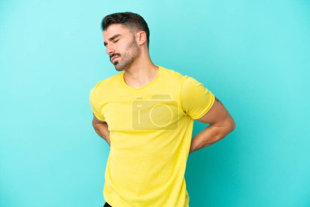 Photo for Young caucasian man isolated on blue background suffering from backache for having made an effort - Royalty Free Image