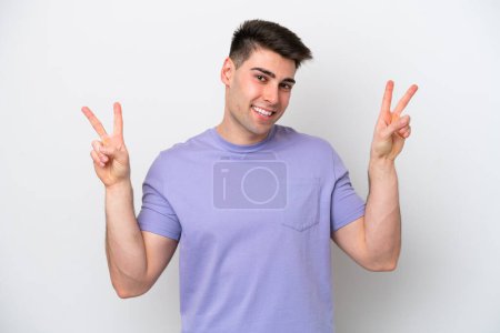 Téléchargez les photos : Young caucasian man isolated on white background showing victory sign with both hands - en image libre de droit