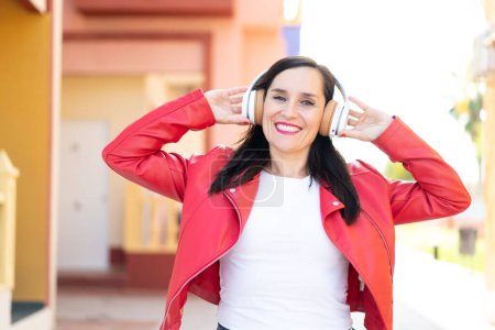 Téléchargez les photos : Femme d'âge moyen écouter de la musique - en image libre de droit