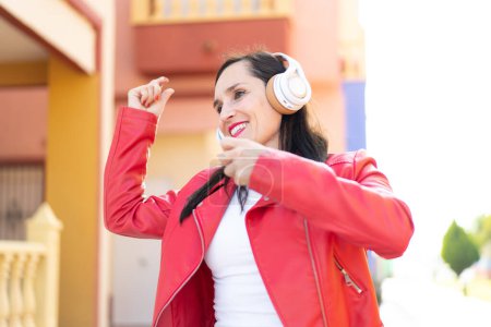 Téléchargez les photos : Femme d'âge moyen écouter de la musique et danser - en image libre de droit