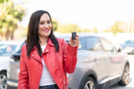 Photo for Middle aged woman holding car keys at outdoors with happy expression - Royalty Free Image