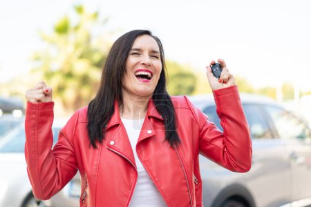Foto de Mujer de mediana edad sosteniendo las llaves del coche y celebrando una victoria - Imagen libre de derechos