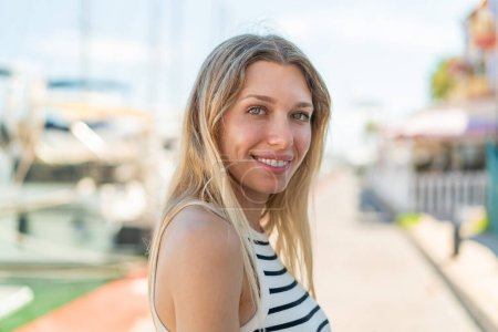 Téléchargez les photos : Jeune femme blonde en plein air Avec une expression heureuse - en image libre de droit