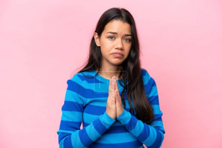 Téléchargez les photos : Young Colombian woman isolated on pink background keeps palm together. Person asks for something - en image libre de droit