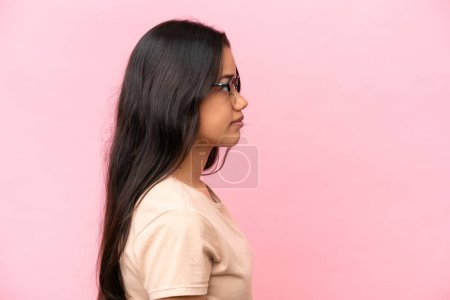 Foto de Mujer colombiana joven aislada sobre fondo rosa con gafas - Imagen libre de derechos