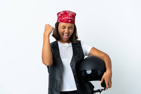 Photo for Young woman holding a motorcycle helmet isolated on white celebrating a victory - Royalty Free Image
