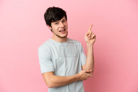 Téléchargez les photos : Jeune homme russe isolé sur fond rose heureux et pointant vers le haut - en image libre de droit