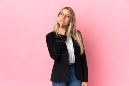 Téléchargez les photos : Femme blonde d'affaires isolée sur fond rose ayant des doutes - en image libre de droit