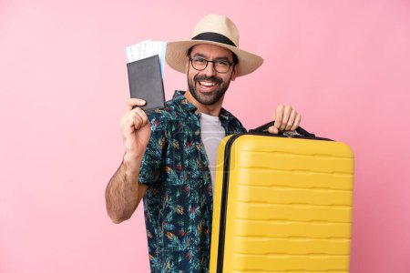 Photo for Young caucasian man over isolated background in vacation with suitcase and passport - Royalty Free Image
