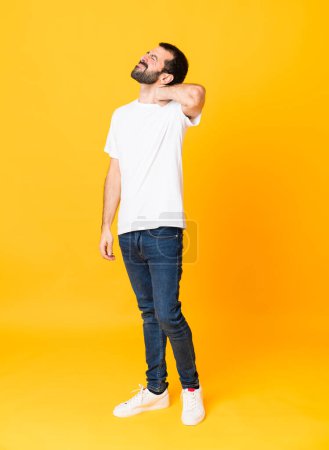 Photo for Full-length shot of man with beard over isolated yellow background with neckache - Royalty Free Image