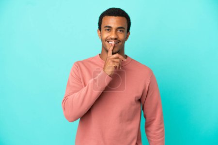 Photo for African American handsome man on isolated blue background showing a sign of silence gesture putting finger in mouth - Royalty Free Image