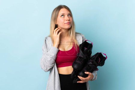 Photo for Young blonde woman holding a roller skates isolated on pink background thinking an idea - Royalty Free Image