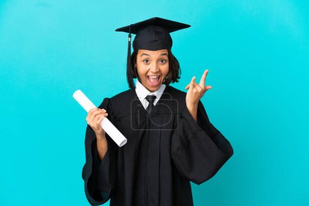 Photo for Young university graduate girl over isolated blue background making horn gesture - Royalty Free Image