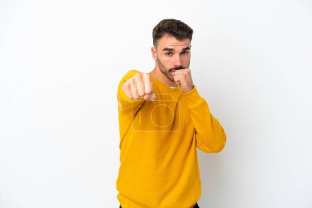 Photo for Young caucasian man isolated on white background with fighting gesture - Royalty Free Image