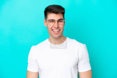 Photo for Young caucasian man isolated on blue background With glasses and happy expression - Royalty Free Image