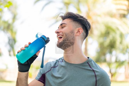 Photo for Young handsome man doing sport with a bottle of water - Royalty Free Image