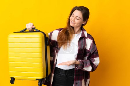 Photo for Young Ireland woman isolated on yellow background in vacation with travel suitcase - Royalty Free Image