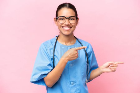 Photo for Young nurse Colombian woman isolated on pink background surprised and pointing side - Royalty Free Image