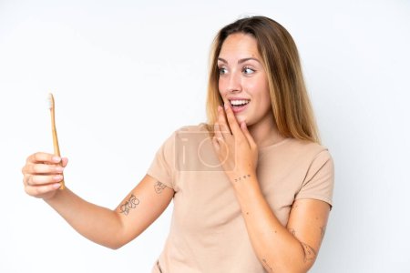 Foto de Mujer joven caucásica cepillándose los dientes aislados sobre fondo blanco con sorpresa y expresión facial conmocionada - Imagen libre de derechos