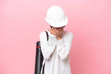 Photo for Young architect Russian woman with helmet and holding blueprints isolated on pink background with tired and sick expression - Royalty Free Image