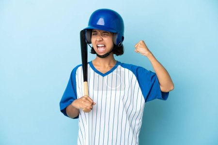 Téléchargez les photos : Baseball mixte femme joueuse avec casque et chauve-souris isolé sur fond bleu faire un geste fort - en image libre de droit