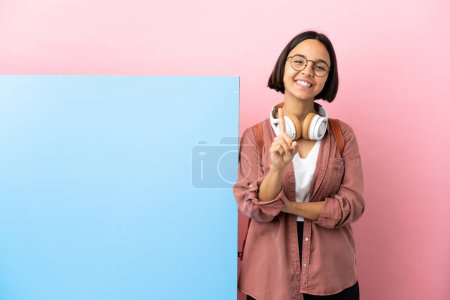 Foto de Young student mixed race woman with a big banner over isolated background showing and lifting a finger - Imagen libre de derechos