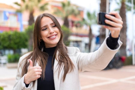 Foto de Joven mujer bonita al aire libre comprar con el móvil con una tarjeta de crédito - Imagen libre de derechos
