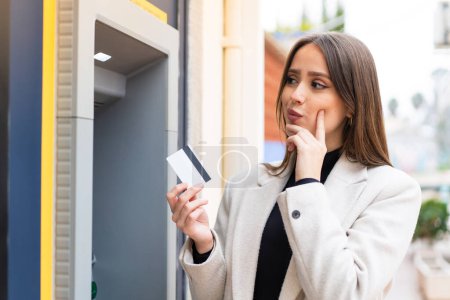 Photo for Young pretty woman using an ATM - Royalty Free Image