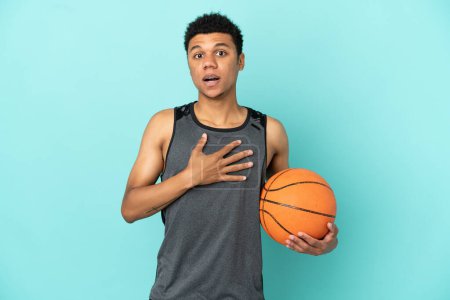 Photo for Basketball player African American man isolated on blue background surprised and shocked while looking right - Royalty Free Image