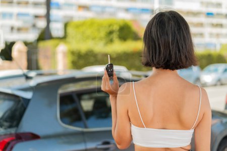 Téléchargez les photos : Jeune jolie bulgare femme tenant des clés de voiture à l'extérieur en position arrière - en image libre de droit