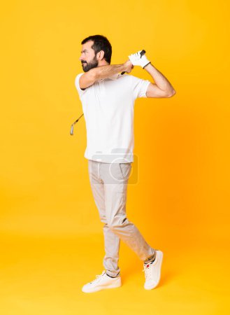 Téléchargez les photos : Plan complet de l'homme sur fond jaune isolé jouant au golf - en image libre de droit