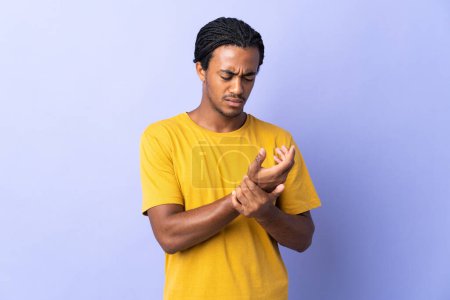 Photo for Young African American man with braids man isolated on purple background suffering from pain in hands - Royalty Free Image