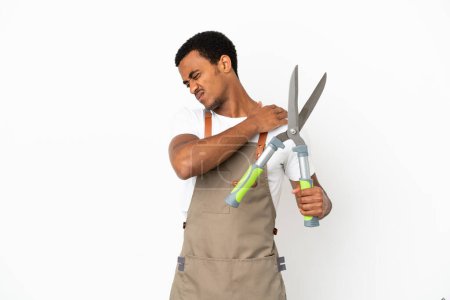 Photo for African American gardener man holding pruning shears over isolated white background suffering from pain in shoulder for having made an effort - Royalty Free Image
