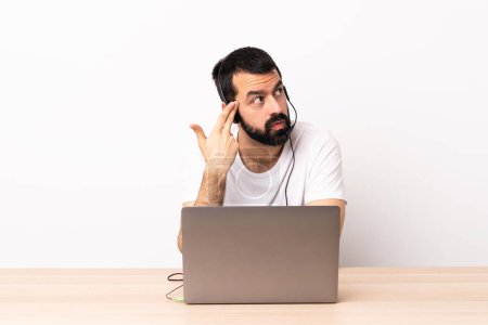 Photo for Telemarketer caucasian man working with a headset and with laptop with problems making suicide gesture. - Royalty Free Image