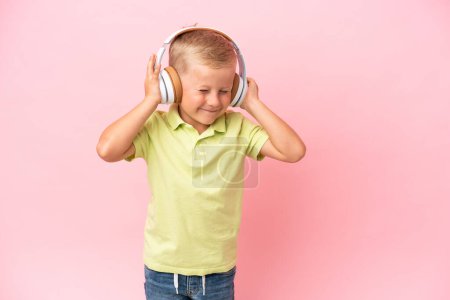 Photo for Little Russian boy listening to music with headphones over isolated background - Royalty Free Image