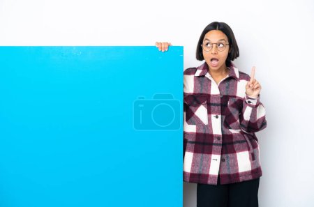 Photo for Young mixed race woman with a big blue placard isolated on white background thinking an idea pointing the finger up - Royalty Free Image