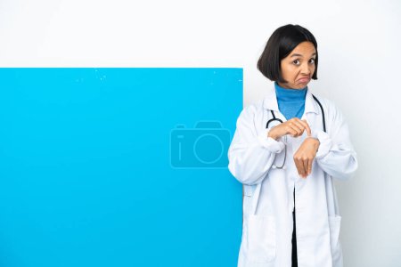 Photo for Young mixed race doctor woman with a big placard isolated on white background making the gesture of being late - Royalty Free Image