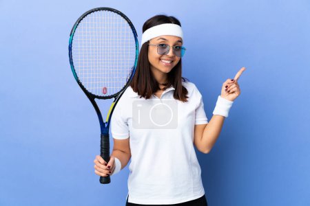 Téléchargez les photos : Jeune joueuse de tennis sur fond isolé heureux et pointant vers le haut - en image libre de droit