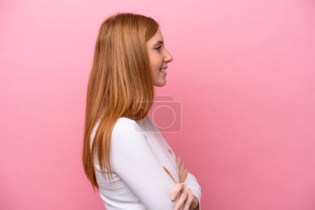 Photo for Young redhead woman isolated on pink background in lateral position - Royalty Free Image