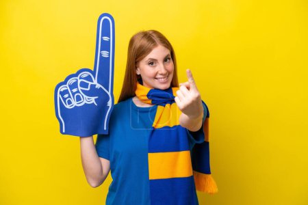 Téléchargez les photos : Jeune femme fan de sport rousse isolé sur fond jaune faisant geste à venir - en image libre de droit