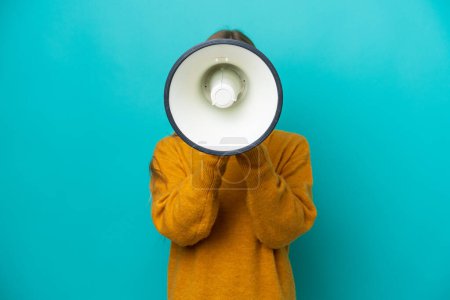Photo for Young Russian woman isolated on blue background shouting through a megaphone to announce something - Royalty Free Image