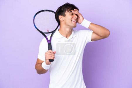 Foto de Guapo joven tenista hombre aislado en ocre fondo sonriendo mucho - Imagen libre de derechos