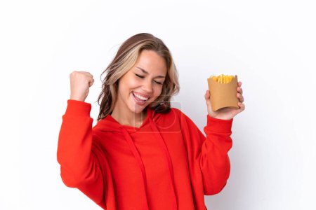 Photo for Young Russian girl holding fried chips isolated on white background celebrating a victory - Royalty Free Image