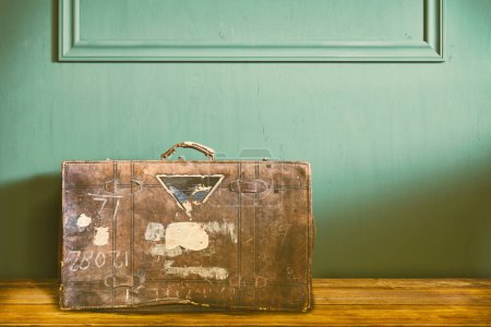 Téléchargez les photos : Image rétro d'une valise de voyage vintage altérée dans un ancien salon - en image libre de droit