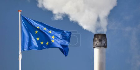 Téléchargez les photos : Waving European flag in front of a polluting factory chimney with smoke - en image libre de droit