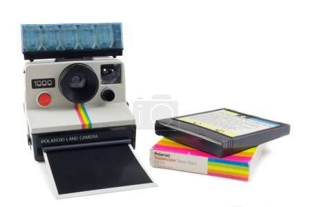 Foto de Dieren, Países Bajos - 27 de octubre de 2023: Antigua cámara fotográfica instantánea Polaroid con flash y paquete de fotos frente a un fondo blanco en Dieren, Países Bajos - Imagen libre de derechos