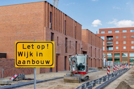 Schild mit dem holländischen Text für "Achtung - Wohngebiet im Bau" vor neuen Einfamilienhäusern in Lent Nijmegen, Niederlande